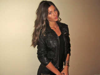 Woman black leather jacket white - a white wall behind her free wallpaper