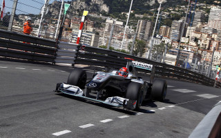 Man driving race car city - tall building free wallpaper