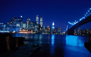 City skyline night bridge boat - the water and a bridge in the foreground free wallpaper