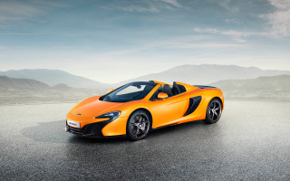 Bright orange sports car mountains - a cloudy sky above free wallpaper