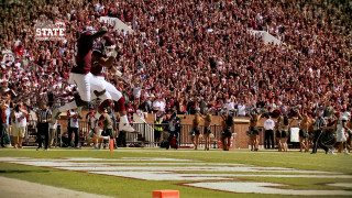 Football player jumping catching ball - a football player free wallpaper