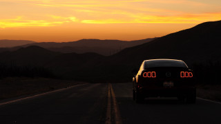Car driving road mountains sunset - orange glow free wallpaper