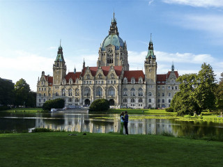 Man standing large building lake - a clock tower free wallpaper