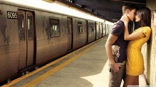Man woman kissing train station 3 - a train in the background free wallpaper