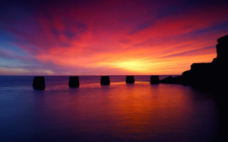 Sunset pillars water clouds sky - a body of water below free wallpaper