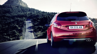 Red car driving mountain range - a sky background and a mountain range in the distance free wallpaper