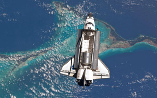 Space shuttle flying ocean landforms - a space shuttle free wallpaper