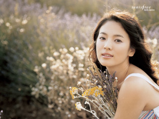 Woman holding flowers field smile - her face and a hand free wallpaper
