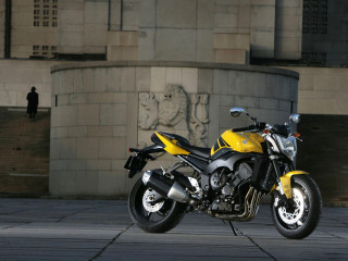 Yellow motorcycle parked building statue - a yellow motorcycle free wallpaper