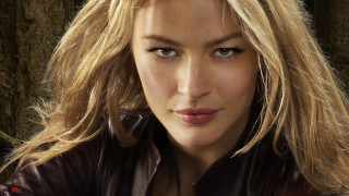 Blonde leather jacket woman pose - a wall behind her free wallpaper