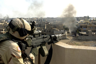Soldier gun city smoke background - his hand and a city in the background free wallpaper