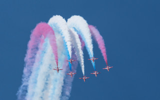 Four airplanes flying formation colored - a blue sky behind them free wallpaper