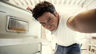 Man leaning refrigerator smiling looking - the camera man free wallpaper