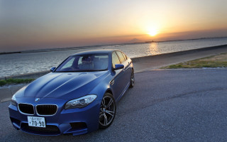 Blue car parked ocean sunset - the side of the road near the ocean free wallpaper
