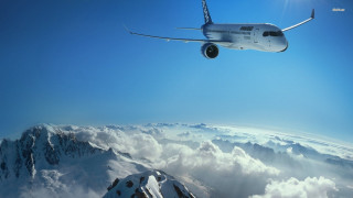 Plane flying mountain range clouds - a few cloud below free wallpaper