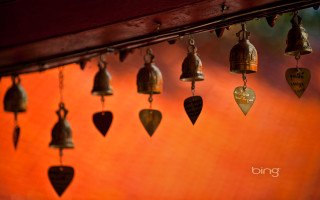 Bells hanging wooden beam red - a red background behind them free wallpaper