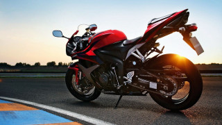 Red motorcycle parked road sunset - the sun shining behind free wallpaper