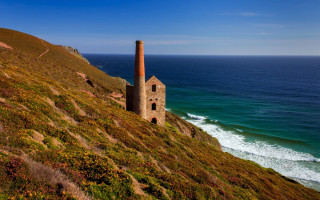 Stone building hill ocean waves - wave free wallpaper