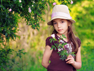 Little girl holding flower hat - a field of flowers free wallpaper
