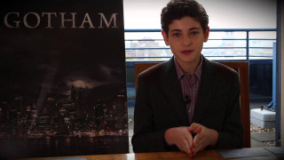 Young man sitting table batman - a city skyline in the background free wallpaper