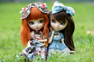 Two dolls sitting grass holding 2 - the other holding free wallpaper