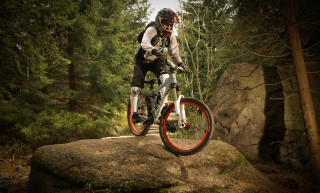 Man riding bike rock woods - the background and a rock in the foreground free wallpaper