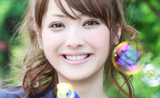 Young woman smiling holding soapy - a young woman free wallpaper