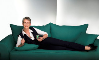Woman sitting green couch drink - her hand and a cell phone free wallpaper