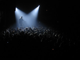 Man standing stage guitar crowd - a guitar in front free wallpaper