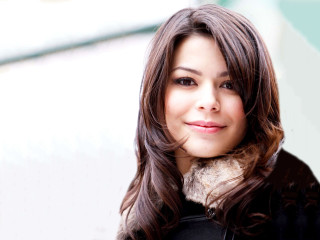 Woman smiling black jacket green - wall behind her free wallpaper