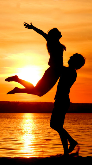 Man woman jumping sunset water - romantic free wallpaper