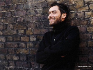 Man leaning brick wall arms - david annand free wallpaper