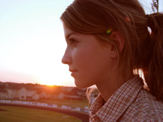 Woman ponytail sunset field houses - a field in the background free wallpaper
