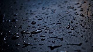 Water droplets black surface dark - a close up of water droplets free wallpaper
