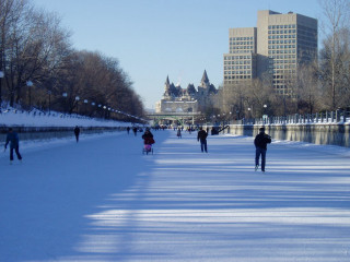 Skating group frozen pond city - tall building free wallpaper