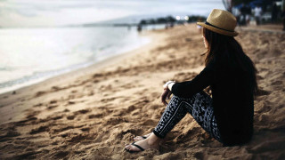Woman sitting beach legs crossed - sea free wallpaper