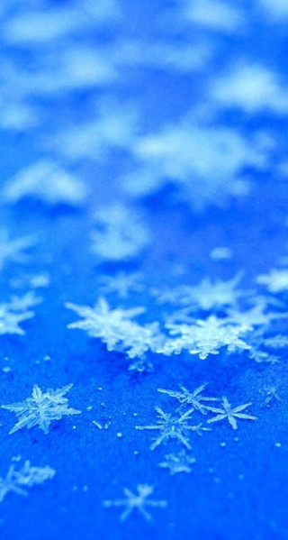 Snowflake closeup blue surface snow - a blurry background free wallpaper