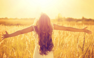 Woman standing field arms outstretched - sunlight free wallpaper
