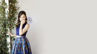 Woman blue dress flower painting - a white wall behind her free wallpaper