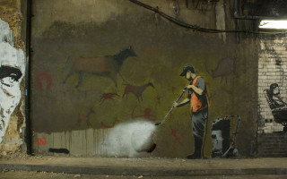 Man spray painting wall animals - dystopian art free wallpaper
