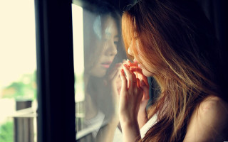 Woman looking out window talking - a cell phone free wallpaper