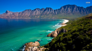 Beach mountains water white sand - a view of a beach free wallpaper