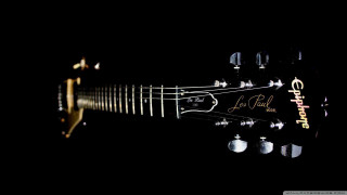 Guitar closeup black background gold - a close up of a guitar free wallpaper