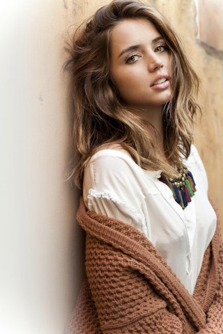 Woman leaning wall sweater necklace - against free wallpaper