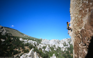 Man climbing mountain rock face - hard edge free wallpaper