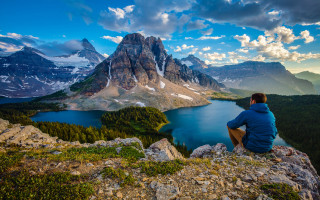 Man sitting rock mountain lake - a rock free wallpaper