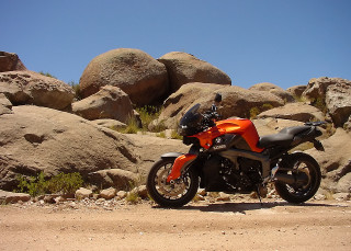 Motorcycle parked rock formation desert - still free wallpaper