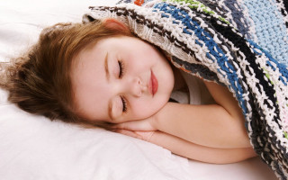 Little girl lying blanket bed - under a blanket free wallpaper