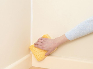 Person cleaning corner wall sponge - a wall free wallpaper