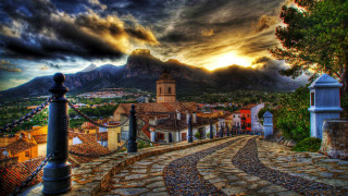 Cobblestone road church village mountains - magic realism free wallpaper for desktop